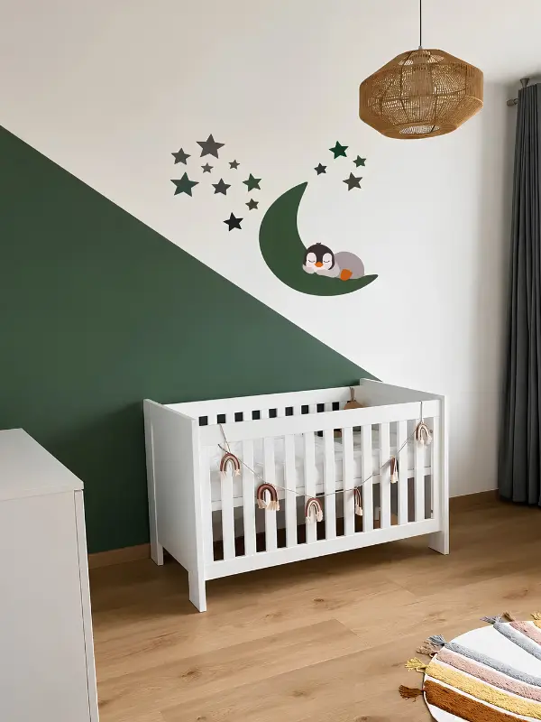 Groene babykamer met een slapende pinguin op een maan behangsticker